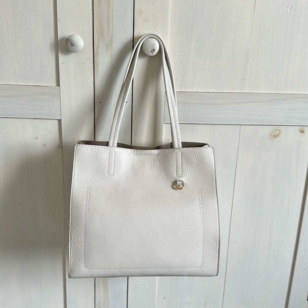 Leather open top tote with snap closure.